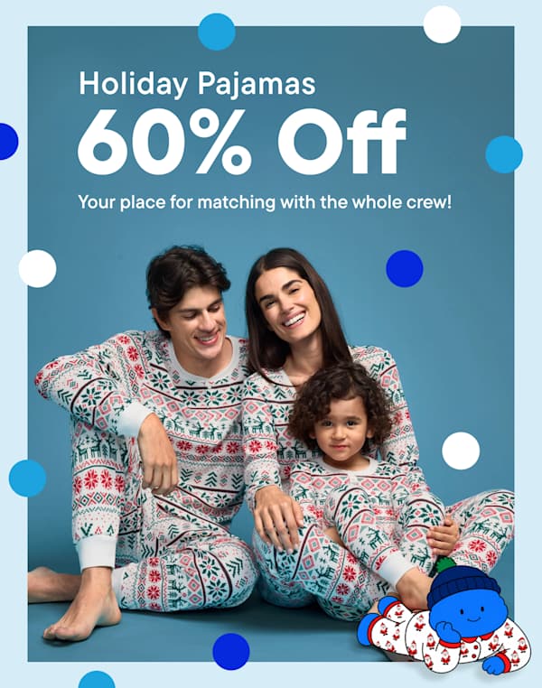 A family of three wearing matching holiday pajamas sits against a blue background featuring promotional text and colorful polka dots | Holiday Pajamas 60% Off