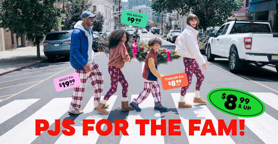 The image shows a group of people, likely friends or family, standing on a city street. They are wearing colorful, patterned clothing and appear to be shopping or browsing at a nearby store, as indicated by the price tags and signs in the foreground.